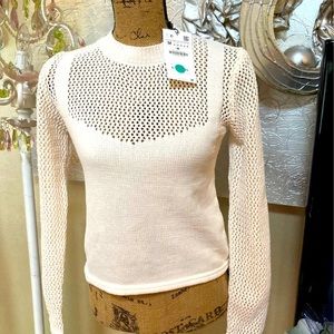 Top with a high neck and long sleeves. Cutwork fabric details.